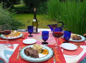 una mesa con platos de comida y una botella de vino en MaisonMazerand, en Cirey-sur-Vezouze