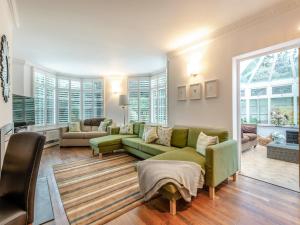uma sala de estar com um sofá verde e cadeiras em Windbrake House em Alverstoke