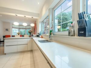 uma cozinha com armários brancos e uma grande janela em Windbrake House em Alverstoke