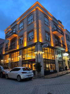 un bâtiment avec deux voitures garées devant lui dans l'établissement HANENDE HOTEL, à Istanbul
