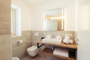 La salle de bains est pourvue d'un lavabo, de toilettes et d'un miroir. dans l'établissement Villa Bea, à Caines
