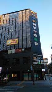 un grand bâtiment avec beaucoup de panneaux dans l'établissement HEARTS Capsule Hotel & Spa Nakasu -Male only-, à Fukuoka
