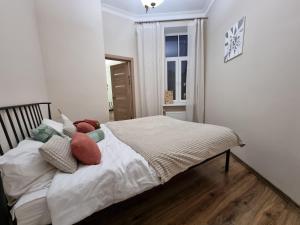 una camera da letto con letto, cuscini e finestra di Art Deco One-Bedroom Suite in Library House with Free 5G WiFi a Riga