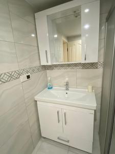 a white bathroom with a sink and a mirror at Royal Sitesi Avsallar in Avsallar