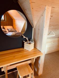 a tiny house with a round mirror and a table at Domki Widokowelove in Gliczarów