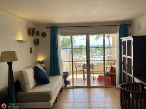 圣安尼Village Vacances Sainte Anne - Vue exceptionnelle Piscine et Plage Vue mer - Barbadine 1010 by Studios Barbadine的带沙发和滑动玻璃门的客厅 更多8张照片