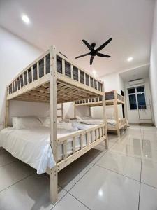 two bunk beds in a room with a ceiling fan at Ngio Homestay Batu Pahat in Batu Pahat