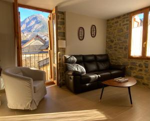 a living room with a leather couch and a chair at Apartamento Casa Francho 3 in Panticosa
