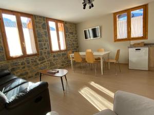 a living room with a table and a kitchen at Apartamento Casa Francho 3 in Panticosa