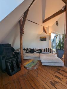 ein Wohnzimmer mit einem Sofa und einem Tisch in der Unterkunft Luxuriöses Penthouse mit Dachterrasse & Massagesessel EM-APARTMENTS DEUTSCHLAND in Bielefeld