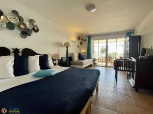 圣安尼Village Vacances Sainte Anne - Vue exceptionnelle Piscine et Plage Vue mer - Barbadine 1010 by Studios Barbadine的一间带大床的卧室和一间客厅