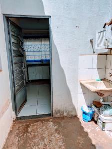 una puerta abierta a una habitación con aseo y lavabo en Casa aconchegante en Campo Grande