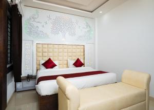 a bedroom with a large bed and a chair at Hotel Maya palace in Bhopal