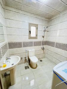 La salle de bains est pourvue de toilettes et d'un lavabo. dans l'établissement El mansour hotel apartmen 93, à Mansoura