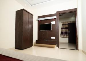 a room with a tv and a wooden cabinet at Hotel Maya palace in Bhopal