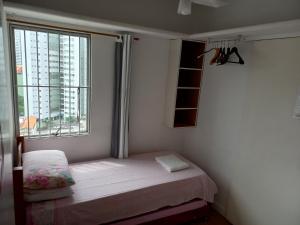 een kleine slaapkamer met een bed en een raam bij Hospedaria Residencial da Torre in Recife