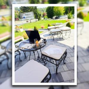 a group of tables and chairs with a laptop on them at Hotel Vertigos in Tuzla