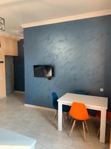 eine blaue Wand mit einem weißen Tisch und Stühlen in der Unterkunft Comfy Apartment in Center in Yerevan