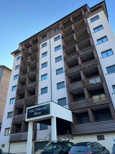 a tall apartment building with a sign on it at Balkan Hill 3 - Apartman TORG in Zlatibor