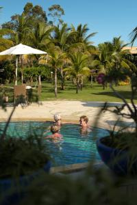 2 personas en la piscina de un complejo en Pousada Barrabella, en Barra Grande
