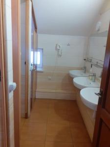 a bathroom with two sinks and a shower at Hostel Stozhary in Ternopilʼ