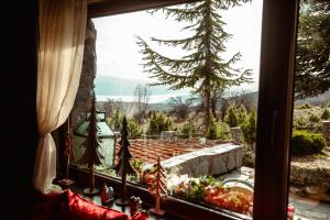 een raam van een huis met uitzicht op een tuin bij E L chalet. A cosy mountain retreat. in Palaios Agios Athanasios
