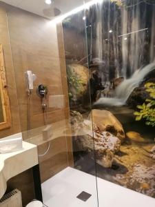 a shower with a waterfall mural in a bathroom at Alte Post in Ellmau