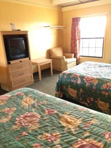 a hotel room with two beds and a television at Scottish Inn - Nashville in Nashville