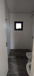baño con 2 aseos y ventana en BLACK BOX CABAÑAS A en Villa Santa Cruz del Lago