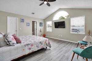 a bedroom with a bed and a flat screen tv at Jax Beach Luxury Oasis W/ Private Pool/Jacuzzi Tub in Jacksonville Beach