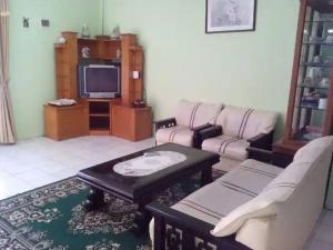 - un salon avec deux canapés et une télévision dans l'établissement Villa Kota Bunga C - Puncak, à Pacet