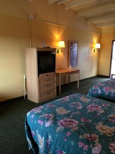 a hotel room with two beds and a flat screen tv at Scottish Inn - Nashville in Nashville