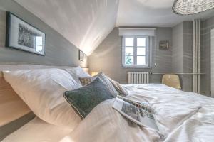 a bedroom with a large bed with white sheets at Anker.Punkt: Einzigartiges Ferienhaus in Rieth am See in Rieth