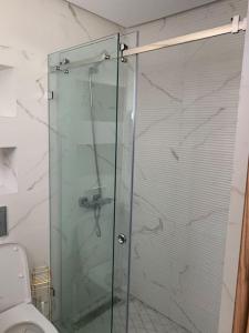 a glass shower in a bathroom with a toilet at Bord de la mer Agadir in Agadir +16 photos