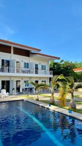 a view of a resort with a swimming pool and palm trees at Villa del OZ Resort in Panglao