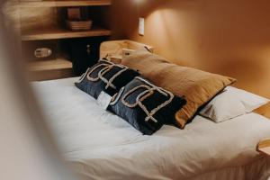 a bed with two pillows on top of it at Hôtel PALMITO in Biarritz