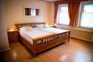 a bedroom with a large bed and two windows at Ferienapartments Schnibbe in Bad Lauterberg
