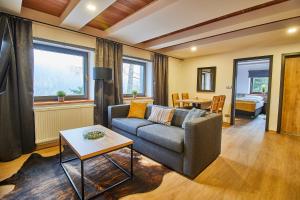 a living room with a couch and a table at Apartmány Výsluní in Špindlerův Mlýn