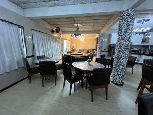 a dining room with tables and chairs and a kitchen at Fantástica Casa Praia Próxima ao Beto Carreiro in Penha