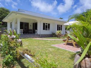 ein kleines weißes Haus mit Garten in der Unterkunft ANV HOLIDAY APARTMENTS in Grand'Anse Praslin