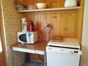 una piccola cucina con forno a microonde e piano cottura di Chalet Les Rocailles a Haudères