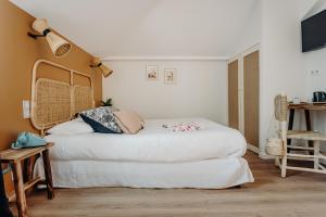 a bedroom with a large white bed in a room at Hôtel PALMITO in Biarritz
