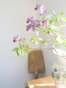 a vase with purple flowers sitting on a table at Lovely, bright apartment overlooking nature in Fiskebäckskil