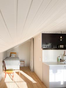 a kitchen with a white ceiling and a table at Lovely, bright apartment overlooking nature in Fiskebäckskil