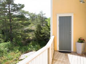 a door on a balcony with a view of trees at Lovely, bright apartment overlooking nature in Fiskebäckskil