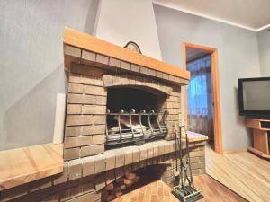 a brick fireplace in a living room with a tv at JAUNA apartments in Jūrmala