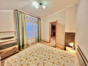 a bedroom with a bed and a large window at JAUNA apartments in Jūrmala