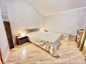 a bedroom with a bed and a wooden floor at JAUNA apartments in Jūrmala