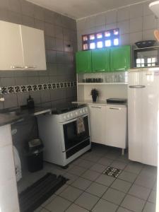 a kitchen with green cabinets and a stove at Privê paraíso do mar in Porto De Galinhas