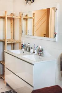 uma casa de banho com um lavatório branco e um espelho. em Villa 4ch 4Sdb à 5min de Nantes em Sainte-Luce-sur-Loire